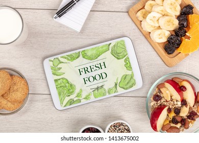 Fresh food on the table with a tablet PC. - Shutterstock ID 1413675002