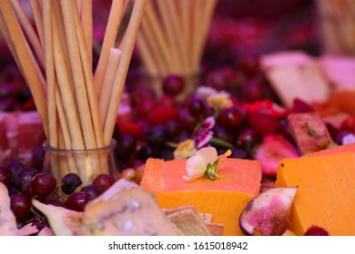 Fresh food platter with bread sticks, purple grapes, cheese, strawberries,figs and flowers.   - Powered by Shutterstock