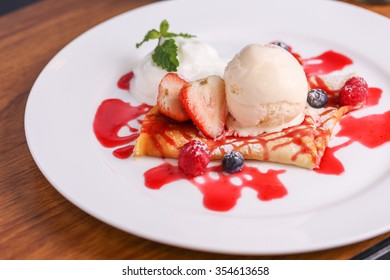 Fresh forest berries Crepes and Ice Cream in white plate on a wood background - Powered by Shutterstock