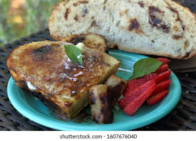 Fresh French Toast Made With Homemade Rustic Bread Served With Breakfast Sausage Link And Sliced Strawberry With Brown Wicker Setting