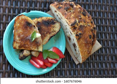 Fresh French Toast Made With Homemade Rustic Bread Served With Breakfast Sausage Link And Sliced Strawberry With Brown Wicker Setting