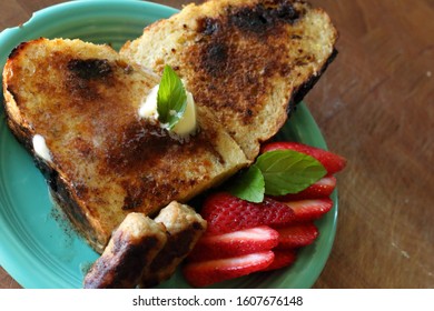 Fresh French Toast Made With Homemade Rustic Bread Served With Breakfast Sausage Link And Sliced Strawberry With Brown Wood Setting