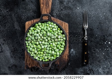 Fresh Frozen green peas in a pan. Black background. Top view Stock photo © 