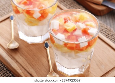 Fresh fruit ice containing pieces of papaya, pineapple and jicama with sweet and sour sauce - Shutterstock ID 2394923569