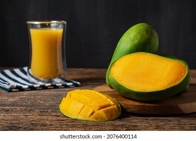 fresh fruit mango and juice manggo on wooden table and black backgrond. whitespace for text