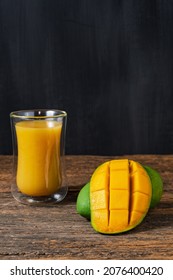 fresh fruit mango and juice mango on wooden table and black backgrond whitespace for text