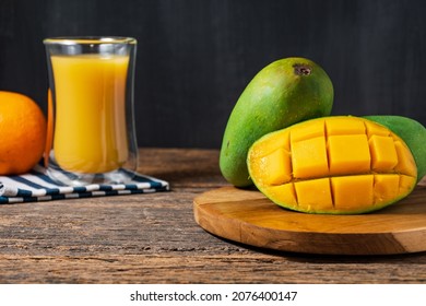 fresh fruit mango, orange and juice mango on wooden table and black backgrond. whitespace