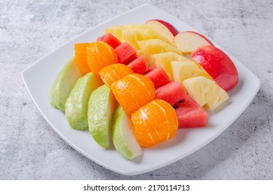 Fresh fruit party on white plate. Beautifully cut apples, oranges, pineapples and guavas. - Powered by Shutterstock