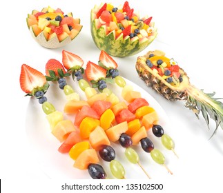 Fresh Fruit Salad Of Mango, Strawberry, Kiwi, Grapes, Strawberries Blueberries Banana In A Bowl From Watermelon Honeydew And Pineapple And Fruit Kebabs, Brochette Isolated On White