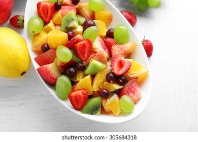 Fresh fruit salad on white wooden table - Shutterstock ID 305684318