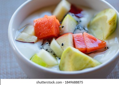 Fresh fruit salad with yogurt in white bowl on clean table background, Healthy Eating,Food for beautiful skin and weight control popular among women who love health, Selective focus.