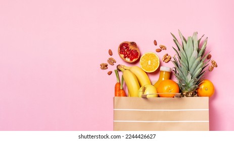 Fresh fruit and vegetables in paper bag on pastel pink background, top view, copy space - Powered by Shutterstock