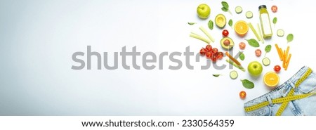 Fresh fruit, vegetables, smoothie falling into jeans and yellow measuring tape instead of belt on white background. Concept of weight loss, detox, diet, healthy clean nutrition, space for text