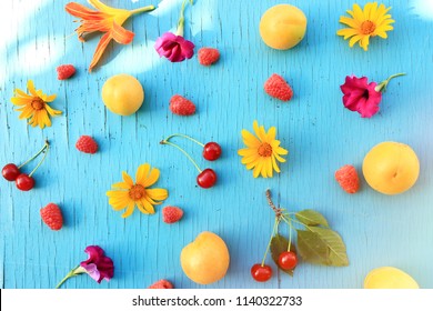 Fresh Fruits And Berries: Apricots, Cherry, Raspberry On A Wooden Turquoise Table Close-up With Bright Summer Flowers. Horizontal View From Above. 