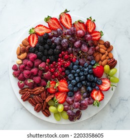 Fresh Fruits, Berries And Nuts On White Marble Board, Healthy Food Concept, Top View