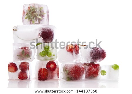 Fresh fruits and vegetable frozen in ice cubes isolated on white background. Fresh healthy summer eating.