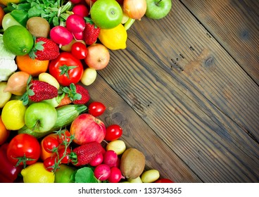 Fresh Fruits And Vegetables On The Old Wooden Board