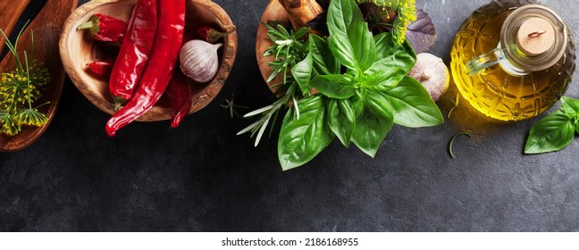 Fresh Garden Herbs In Mortar, Chili Pepper And Olive Oil On Stone Table. Basil, Rosemary, Dill. Cooking Ingredients. Flat Lay