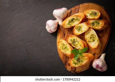 Fresh Garlic Bread With Herbs On A Wooden Board, Top View