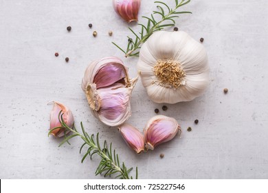 Fresh garlic with rosemary and pepper on white concrete board. - Shutterstock ID 725227546