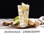 Fresh ginger ale drink in tall glass on wooden table