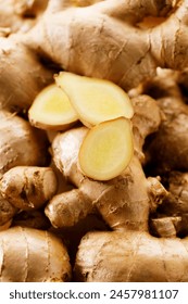 Fresh ginger root and slices on wooden background.