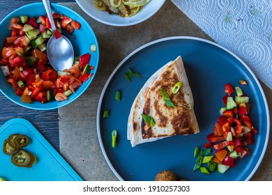 Fresh Gluten Free Tortilla Wrap Burned On A Pan Stuffed With Chickpea Falafel, Fresh Vegetables Chopped Salad, Fried Onion Rings, Jalapenos, Mayo And Scallions. Tasty Meal Preparation. Top View.