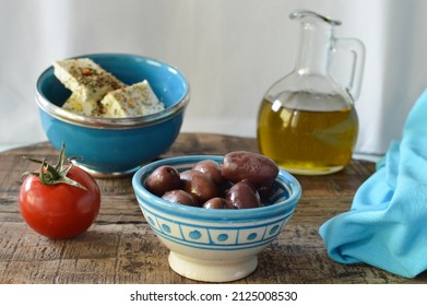 Fresh Greek ingredients, olives, olive oil,feta cheese, for dinner, appetizers, with Greek blue color on the rustic background - Powered by Shutterstock