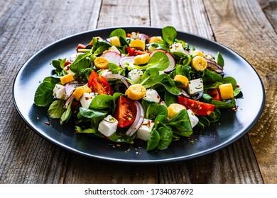 Fresh greek salad - feta cheese, cherry tomatoes, lettuce and onion wooden table  - Powered by Shutterstock