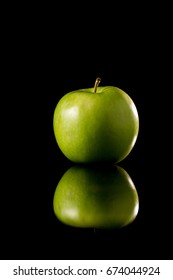 Fresh Green Apple On A Black Reflective Background, Studio Shot,