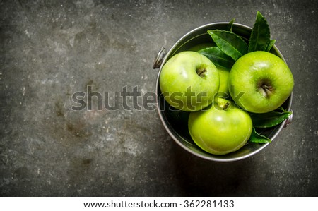 Fresh green apples in the bucket. On rustic stone background. Free space for text . Top view