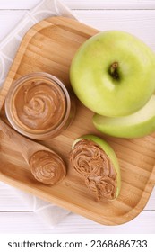 Fresh green apples with peanut butter on white wooden table, top view - Shutterstock ID 2368686733
