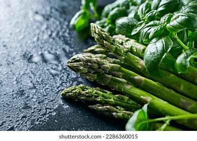 Fresh green asparagus and basil on dark stone background - Powered by Shutterstock