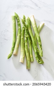 Fresh green asparagus on white marble table. Flat lay with vegan food ingredient healthy food from above