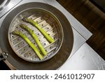 Fresh green asparagus steaming in a metal steamer over a pot of boiling water, healthy cooking concept.