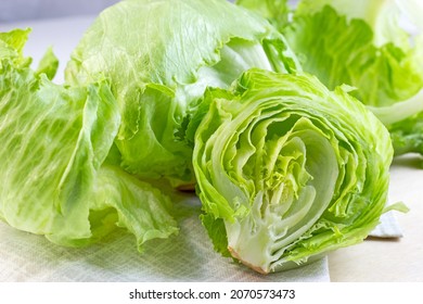 Fresh green iceberg lettuce salad leaves cut on light background on the table in the kitchen