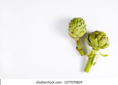Fresh green Italian Artichoke isolated on white background. Organic local produce vegetable. Vegan diet. Clean eating concept. Close up, top view, flat lay.