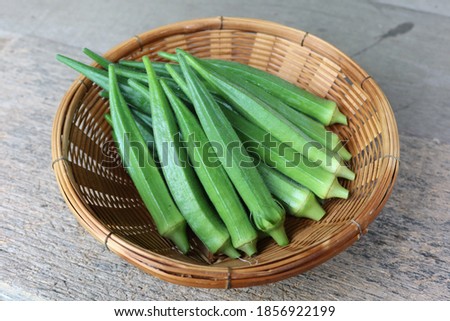 fresh green okra on woven basket