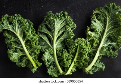 Fresh Green Organic Kale Leaves On Dark Background. Top View