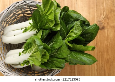 Fresh Green Pak Choy Cabbages In Wicker Basket On Wooden Table, Top View