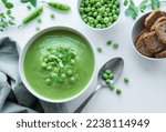 Fresh green pea soup bowl on white  tile background