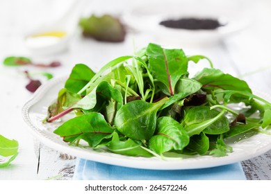 Fresh Green Salad With Spinach, Arugula, Romaine And Lettuce And Sesame Seeds On A Rustic White Background, Selective Focus