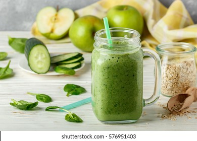 Fresh green smoothie from fruit and vegetables for a healthy lifestyle and ingredients for making dietary drink (spinach, green Apple, cucumber, oatmeal). Selective focus