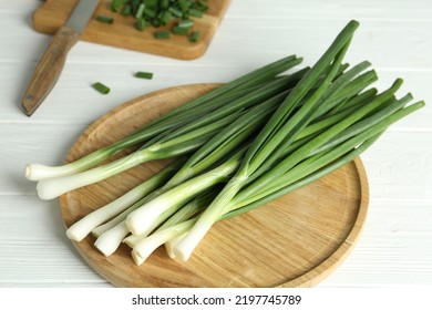 Fresh green spring onions on white wooden table