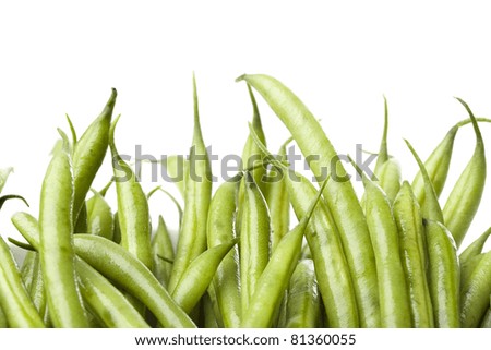 A fresh green string bean against a white background