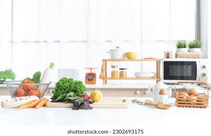 Fresh green vegetable and yellow lemon placed on cutting board, tomatoes, white radish, cos salad in basket, carrots, corn, eggs in egg stand and basket on table. Healthy food in home kitchen - Powered by Shutterstock