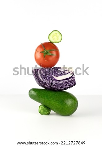 Fresh green vegetables balance on the table. Equilibrium floating food balance of avocado, brussels sprouts, tomatoes, purple cabbage on a white background. High quality photo