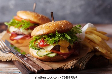 Fresh grilled beef burger and french fries on a rustic wooden table