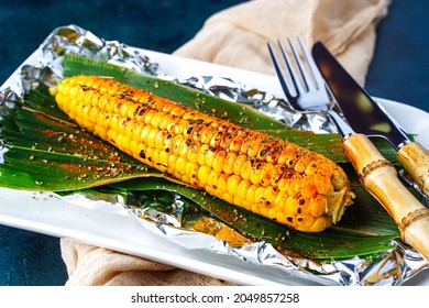 Fresh Grilled Corn On A Plate With Pepper And Spices. BBQ Corn Cob, Vegan Vegetable Meal, Barbecue