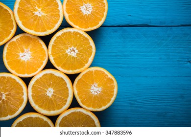 Fresh half cut oranges on wooden blue table